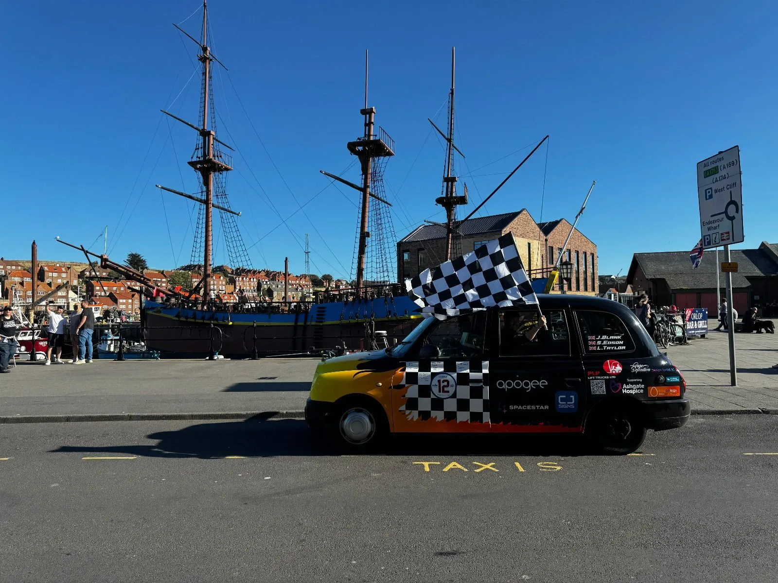 The taxi parked in front of the HMS Endeavour replica in Whitby