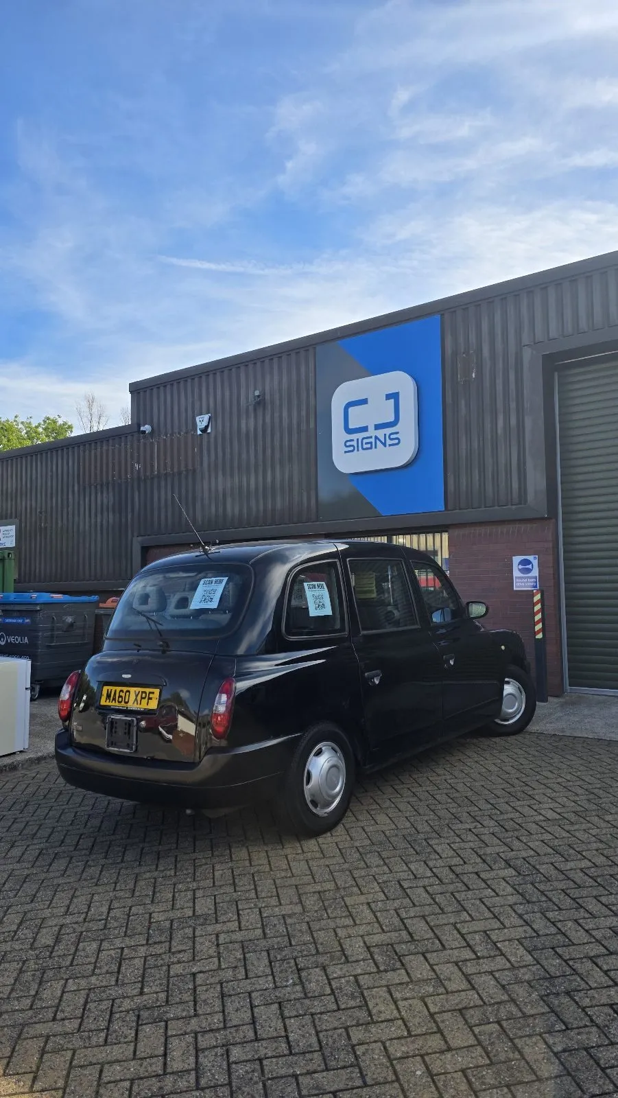 The black taxi parked outside CJ Signs, ready to be wrapped